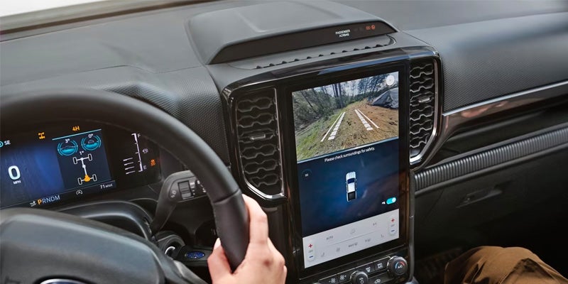 Driver using Ford Ranger’s touchscreen with rearview camera.