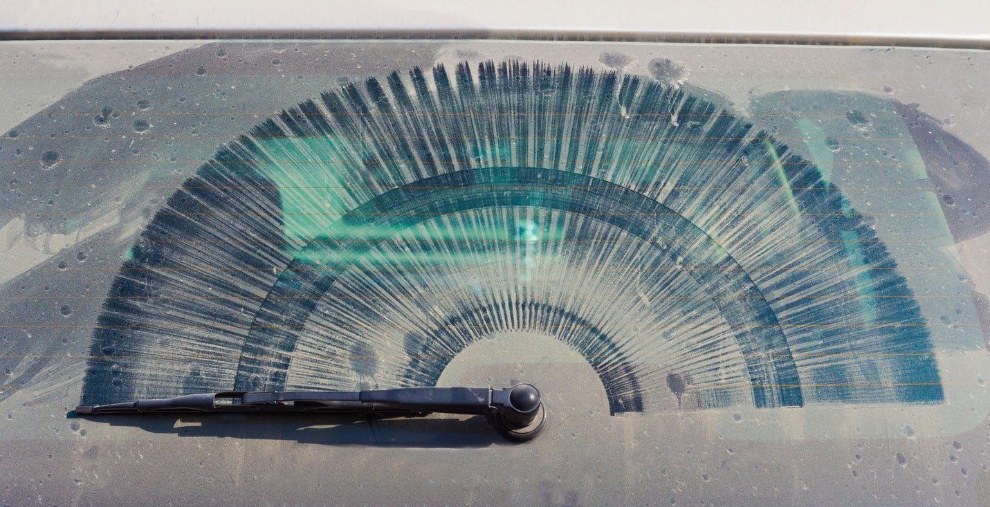 A windshield with a wiper that is streaking.